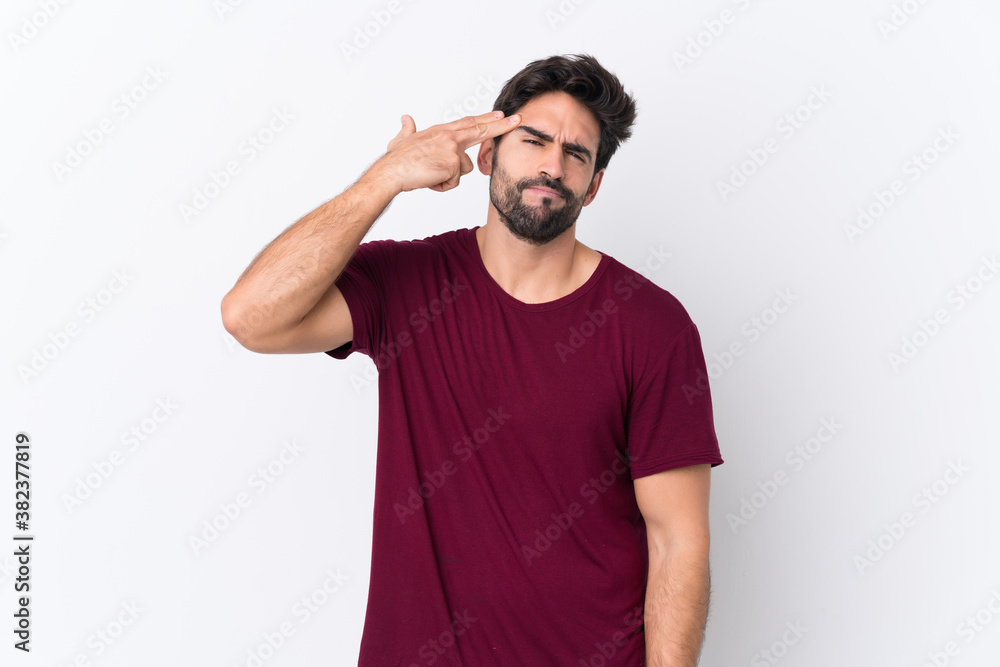 Young handsome man with beard over isolated white background with problems making suicide gesture Young handsome man with beard over isolated white background with problems making suicide gesture