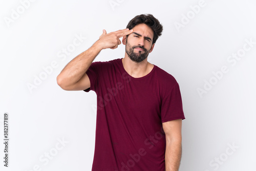 Young handsome man with beard over isolated white background with problems making suicide gesture