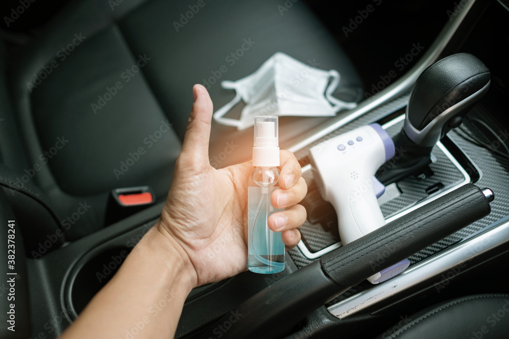 digital Infrared thermometer and alcohol hand gel and protect mask on the car, concept for covid19
