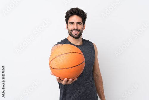 Young handsome man with beard over isolated white background playing basketball © luismolinero