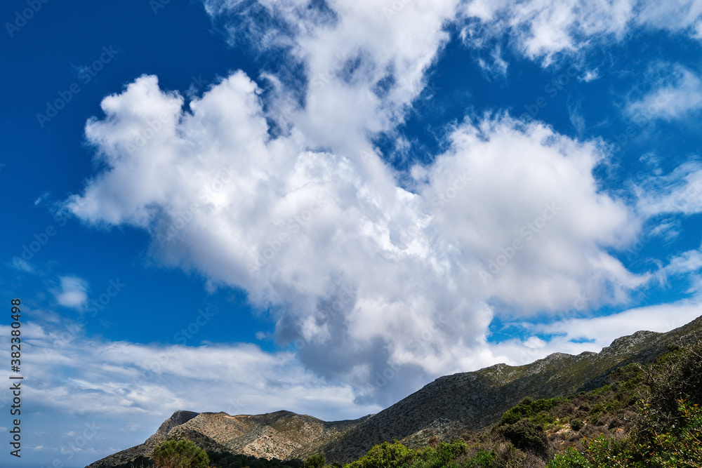Great dynamic clouds in beautiful blue sky over hills and slope at daytime. Typical Greek landscape in spring. Great dynamic clouds in beautiful blue sky over hills and slope at daytime. Typical Greek landscape in spring.