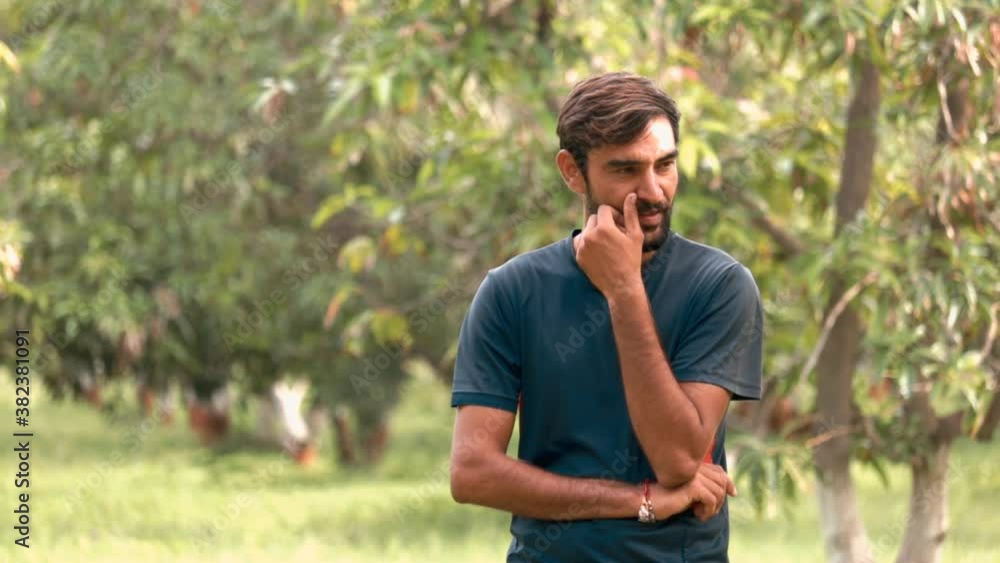 Indian young man with a mustache smiling,indian young man laughing,man bearded hipster twisting mustache,Smiling boy in a mango garden
