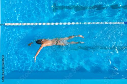 Man training in swimming pool, top view