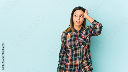 Young woman isolated on blue background being shocked, she has remembered important meeting.
