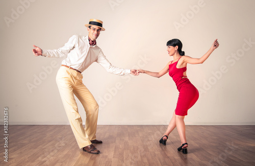 Two swing dancers dancing on a wooden floor photo