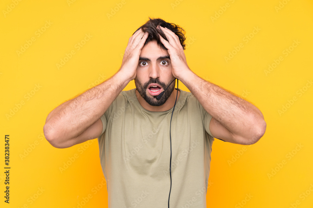 Telemarketer man working with a headset over isolated yellow background with surprise facial expression Telemarketer man working with a headset over isolated yellow background with surprise facial expression