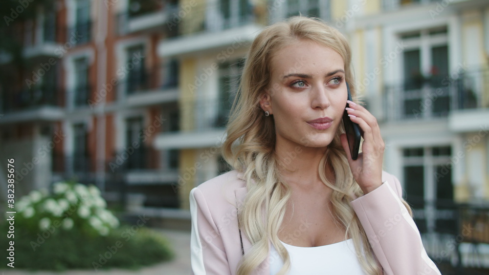 Closeup businesswoman walking in suit. Businesswoman talking phone outdoors Closeup businesswoman walking in suit. Businesswoman talking phone outdoors