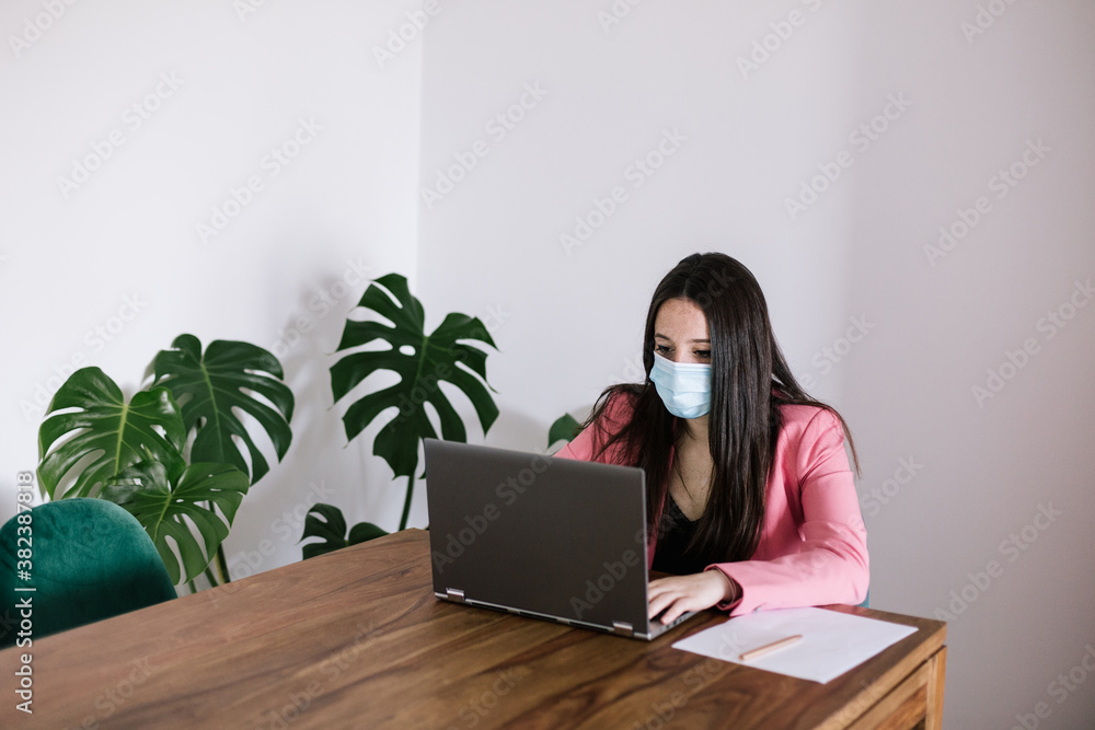 woman at her job as an accountant with a mask for prevention woman at her job as an accountant with a mask for prevention