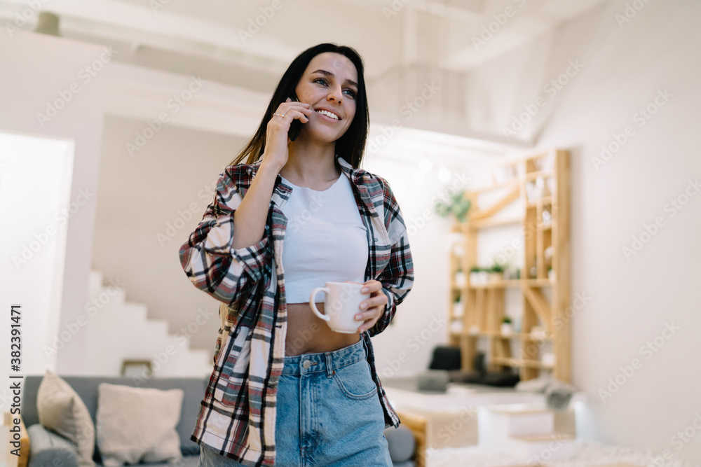 Positive woman talking on phone in living room Positive woman talking on phone in living room