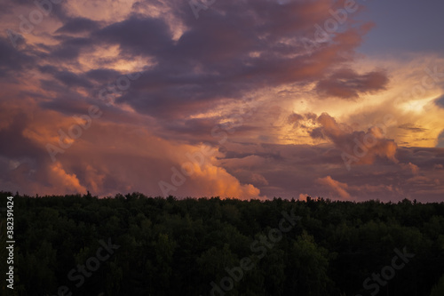 There are dramatic clouds in the dark sky as the sun sets. The sky is dominated by fuchsia, pink.