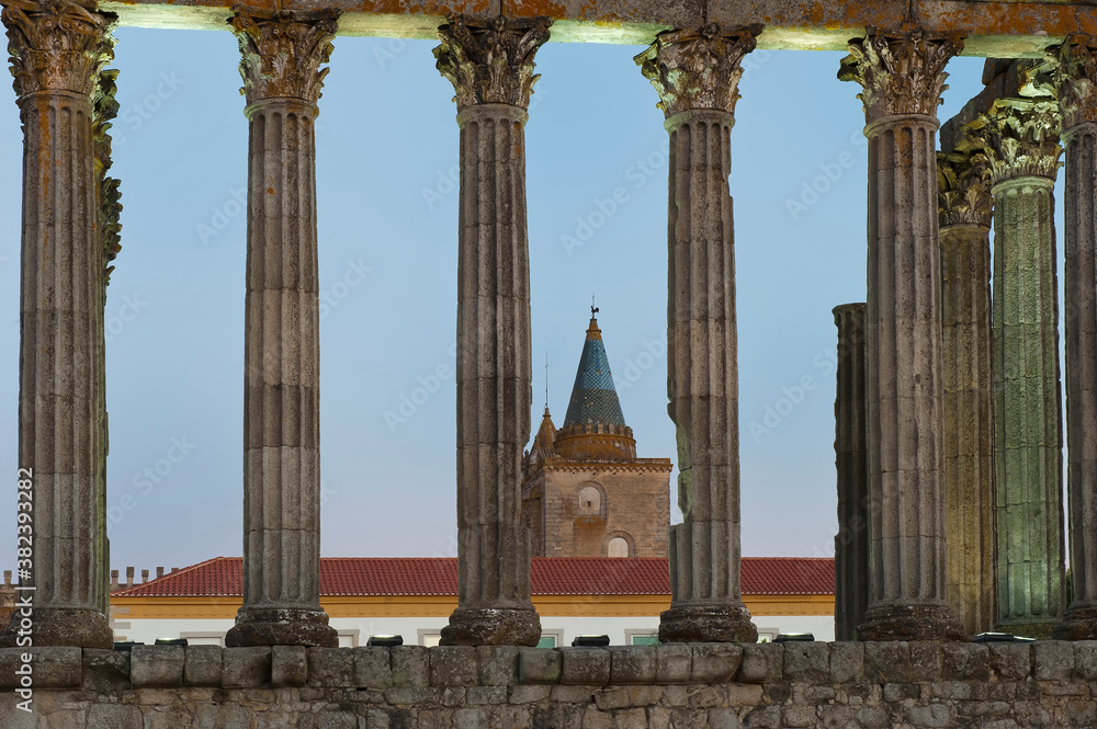 Fototapeta premium Roman temple of Diana at sunset, Santa Maria cathedral in the background, Evora, Alentejo, Portugal, Unesco World Heritage Site