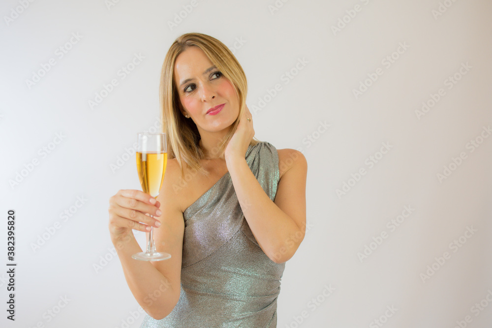 Young celebrating woman silver dress . Beautiful model portrait isolated over studio background hold wine glass. Young celebrating woman silver dress . Beautiful model portrait isolated over studio background hold wine glass.