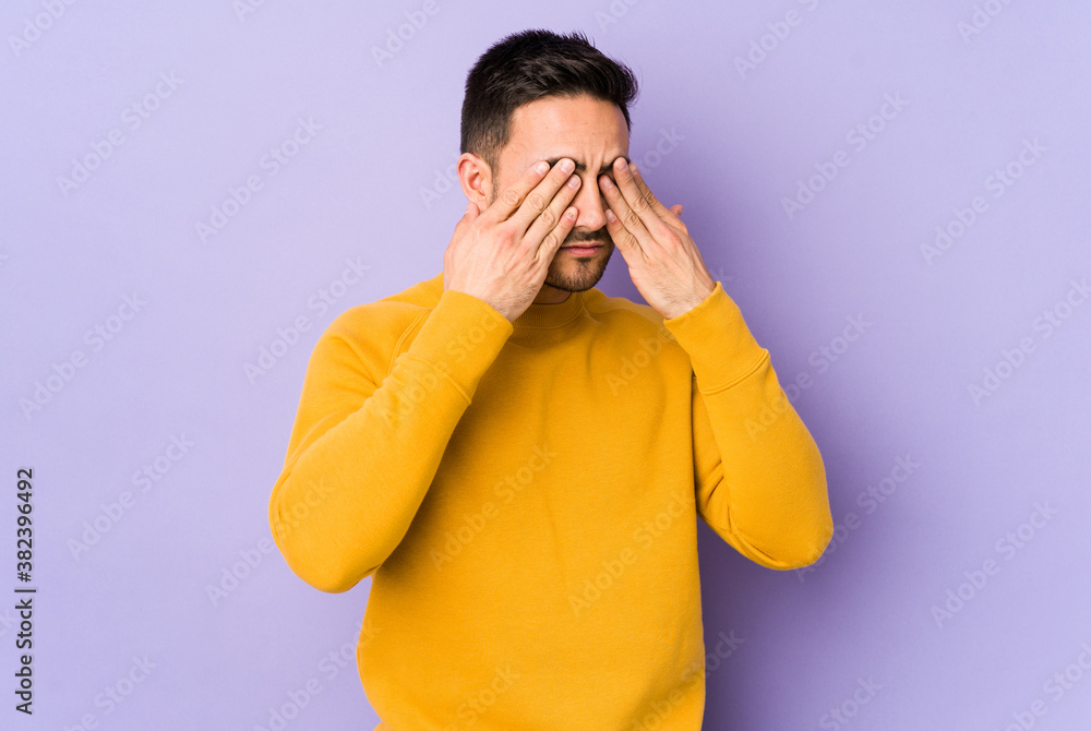 Young caucasian man isolated on purple background afraid covering eyes with hands. Young caucasian man isolated on purple background afraid covering eyes with hands.
