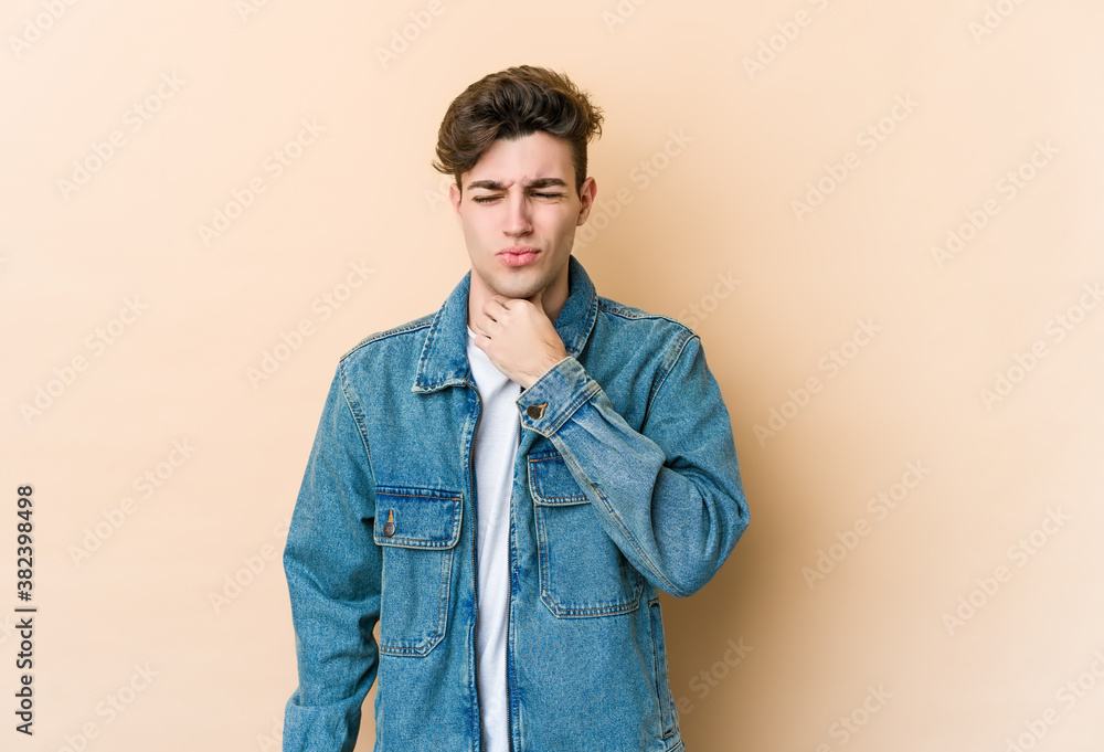 Young caucasian man isolated on beige background suffers pain in throat due a virus or infection. Young caucasian man isolated on beige background suffers pain in throat due a virus or infection.