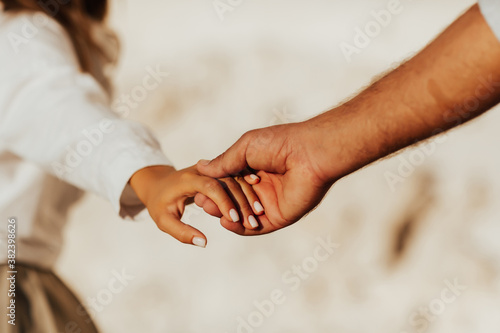 Lovely couple holding hands on white background. Couple together outdoors in love and romantic relationship. Close-up of hands. photo