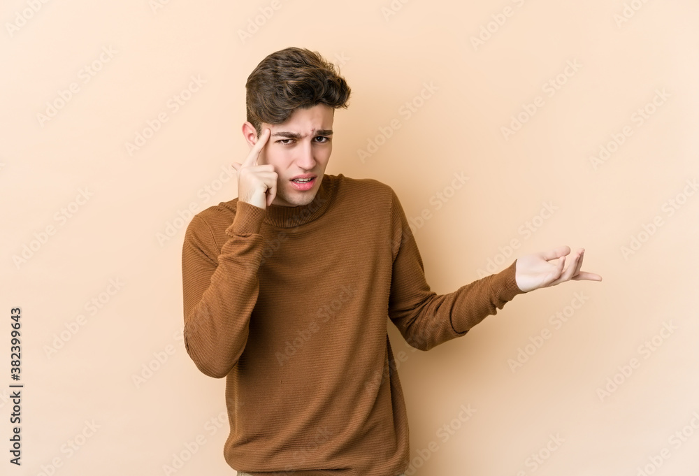 Young caucasian man isolated on beige background showing a disappointment gesture with forefinger. Young caucasian man isolated on beige background showing a disappointment gesture with forefinger.