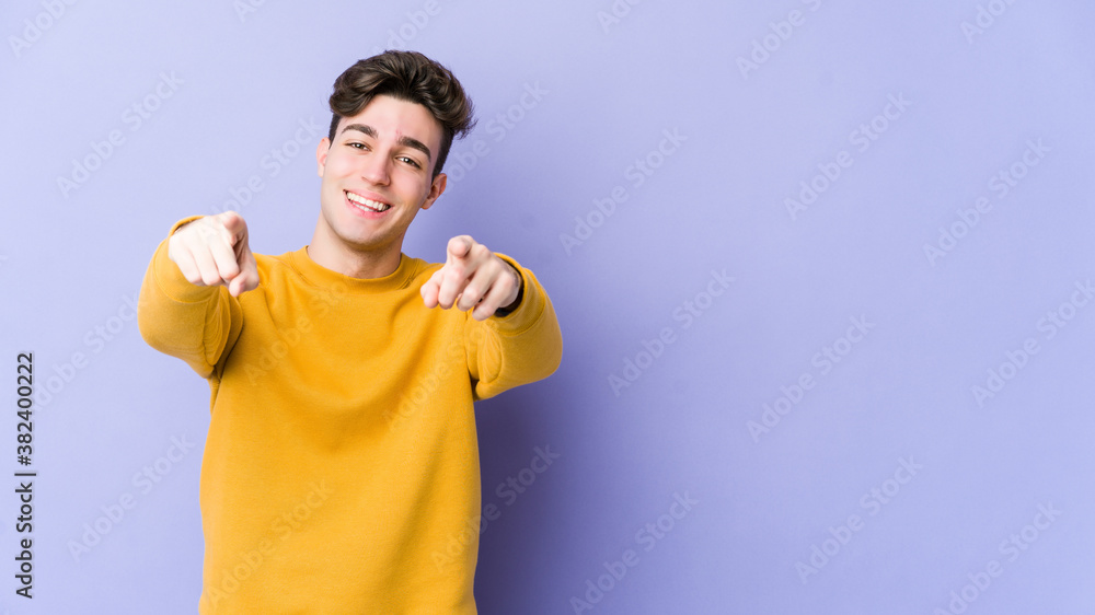 Young caucasian man isolated on purple background cheerful smiles pointing to front. Young caucasian man isolated on purple background cheerful smiles pointing to front.