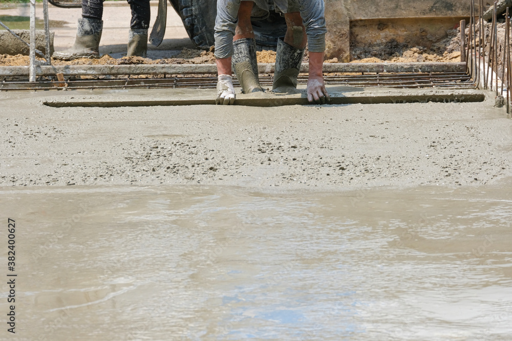 worker man working wet cement floor by use trowel hands spreading poured concrete for strong street after dry. worker man working wet cement floor by use trowel hands spreading poured concrete for strong street after dry.