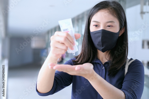 business woman wear mask using hand sanitizer gel