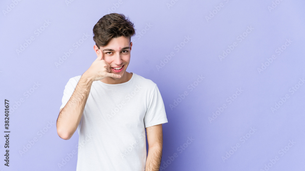 Young caucasian man isolated on purple background showing a mobile phone call gesture with fingers. Young caucasian man isolated on purple background showing a mobile phone call gesture with fingers.
