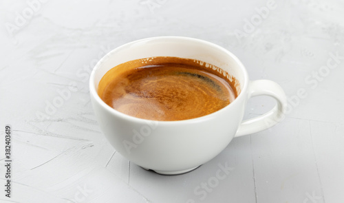 White cup of hot coffee americano on concrete background