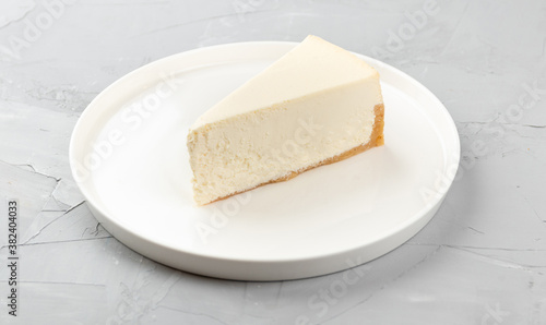 Homemade cheese cake on a white dish on a concrete background
