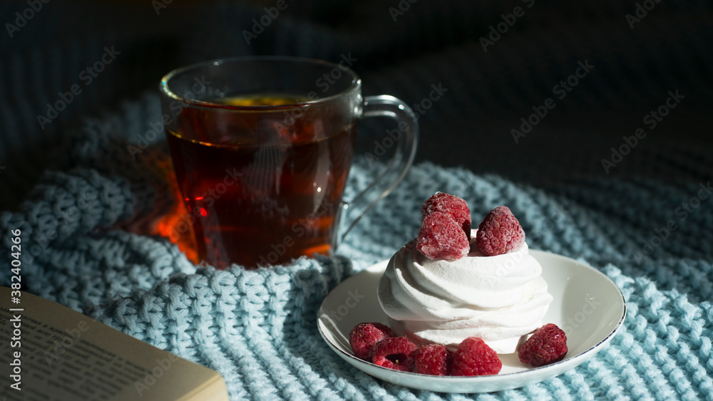 Photo of cozy free time. Book, cup of tea and a beautiful dessert Photo of cozy free time. Book, cup of tea and a beautiful dessert