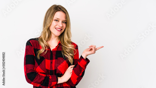 Young cauciasian woman isolated on white background smiling cheerfully pointing with forefinger away. photo