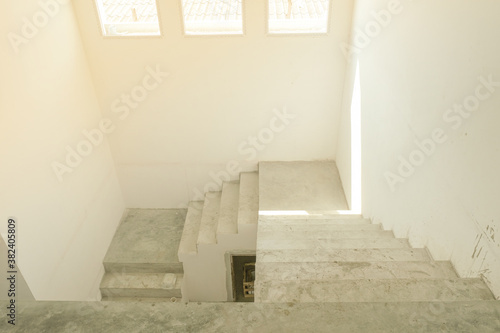 abstract stair concrete in new house structure use lightweight cement brick and white lintel plaster to joint for reinforce in site. three window with glass for sunlight.