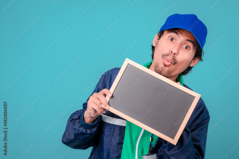 Asian Delivery Guy Showing Empty White Poster, Blue Background, Mockup Asian Delivery Guy Showing Empty White Poster, Blue Background, Mockup