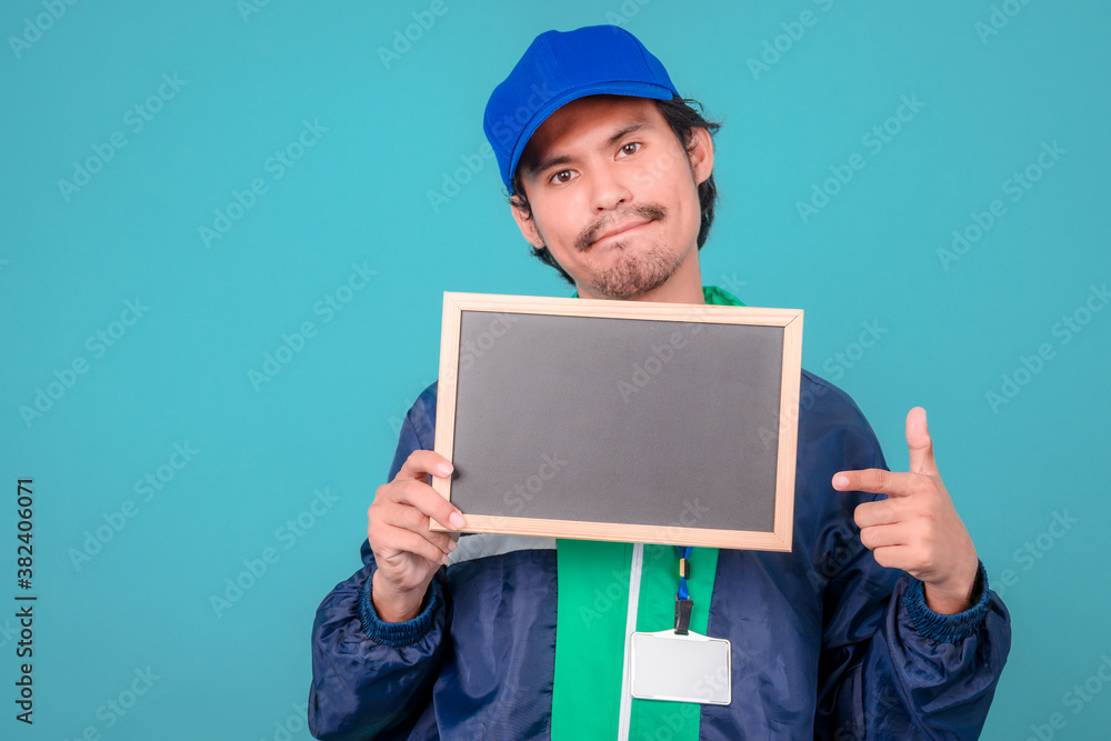 Asian Delivery Guy Showing Empty White Poster, Blue Background, Mockup Asian Delivery Guy Showing Empty White Poster, Blue Background, Mockup