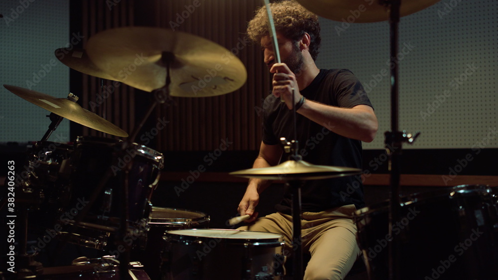 Obraz premium Rock musician hitting drum cymbals in concert hall. Drummer playing on drum kit.