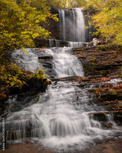 Cascading waterfall with light rays during the Fall