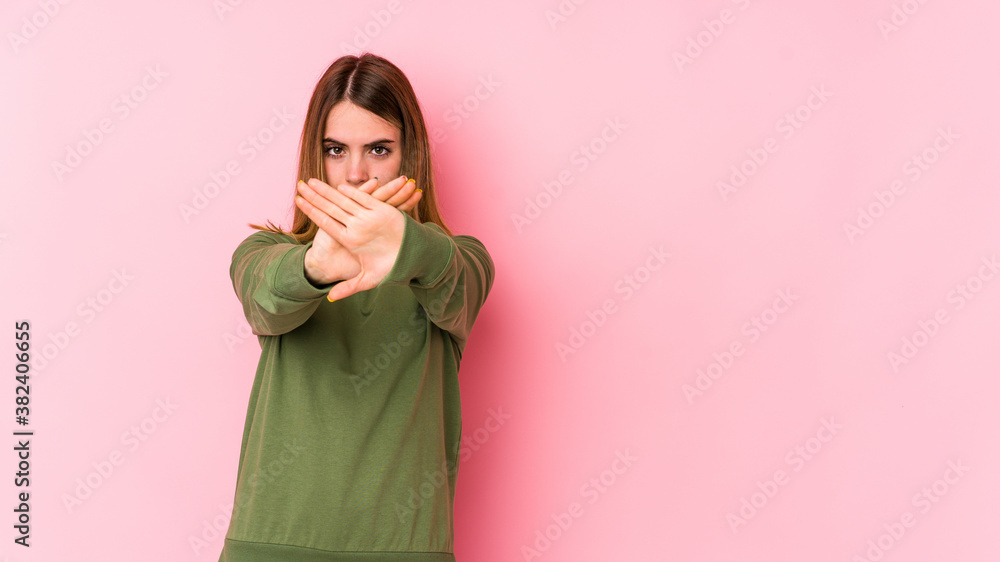 Obraz premium Young caucasian woman isolated on pink background doing a denial gesture