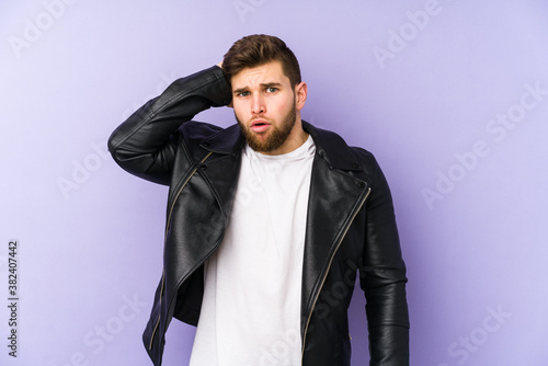 Young man isolated on purple background being shocked, she has remembered important meeting.