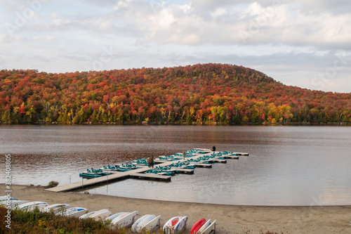 Mont-Orford national park, Canada - october 2020 : autumnal view of the lake Stukely with a wooden quay and nautical embarcations  photo