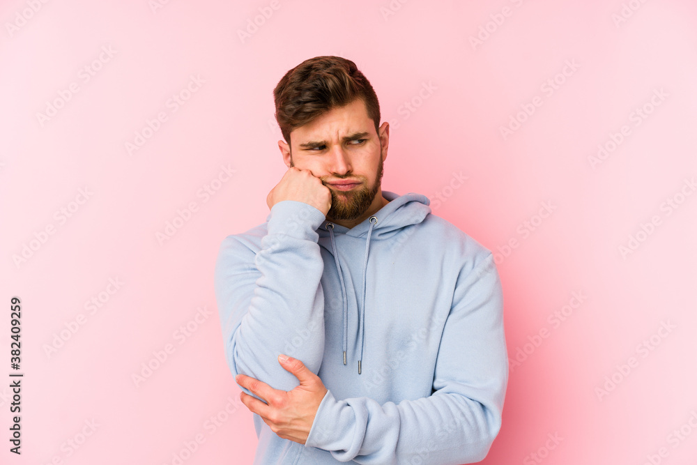 Young caucasian man isolated on pink background who feels sad and pensive, looking at copy space. Young caucasian man isolated on pink background who feels sad and pensive, looking at copy space.