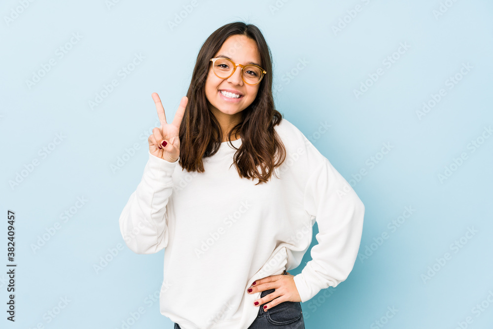 Young mixed race hispanic woman isolated showing victory sign and smiling broadly. Young mixed race hispanic woman isolated showing victory sign and smiling broadly.