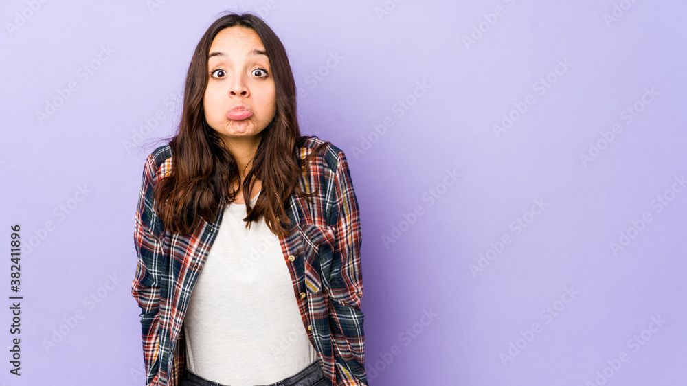 Young mixed race hispanic woman isolated shrugs shoulders and open eyes confused. Young mixed race hispanic woman isolated shrugs shoulders and open eyes confused.