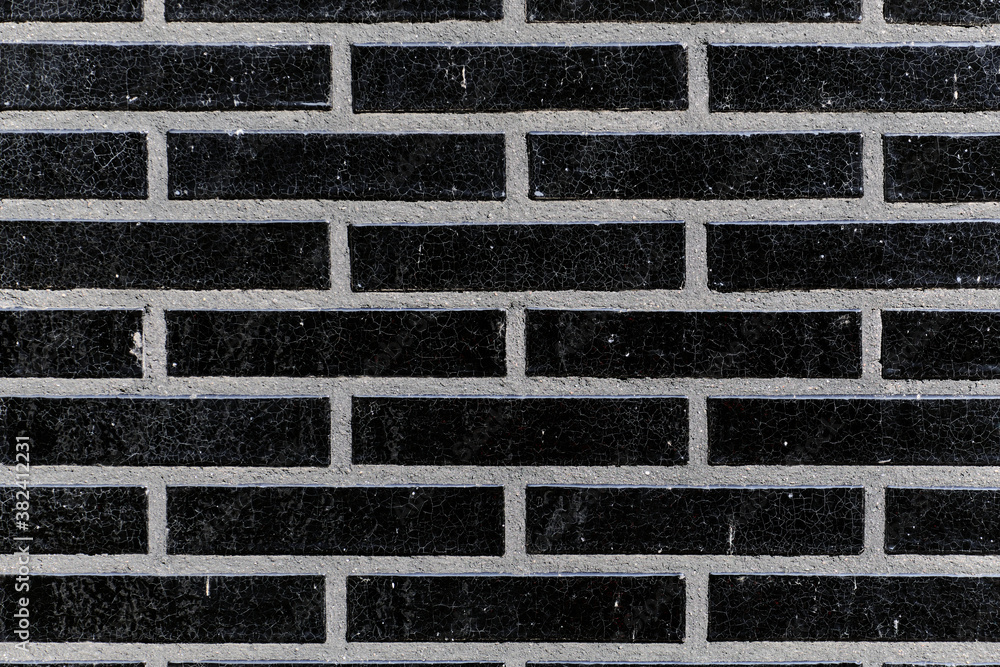 The black glossy brick wall of a modern apartment building. Modern nordic architecture. Pattern of brick wall.