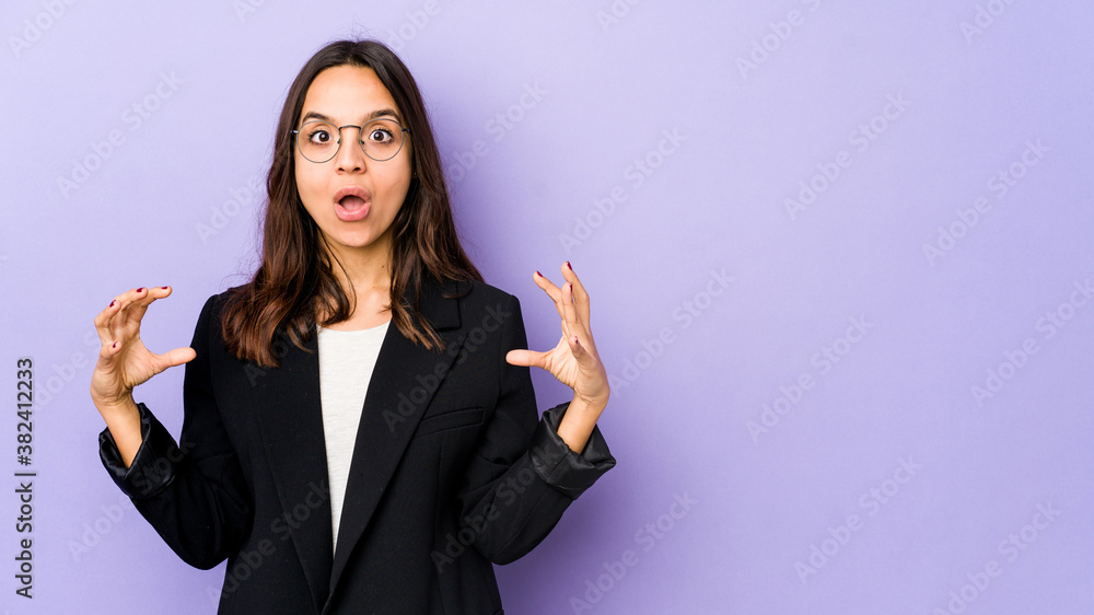 Young mixed race hispanic woman isolated holding something with palms, offering to camera. Young mixed race hispanic woman isolated holding something with palms, offering to camera.