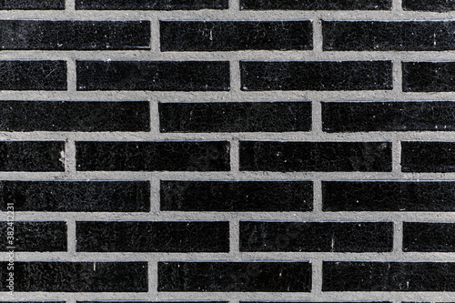 Obraz na płótnie The black glossy brick wall of a modern apartment building. Modern nordic architecture. Pattern of brick wall. w salonie