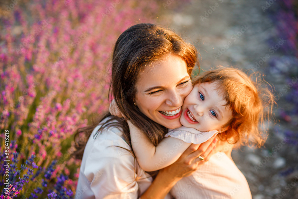 Mother hugs daughter at sunset in the lavender field. Mother hugs daughter at sunset in the lavender field.
