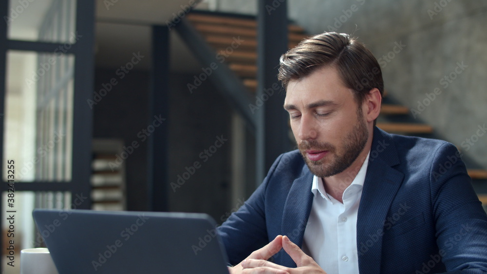 Joyful businessman making web call on laptop camera. Guy making conference call