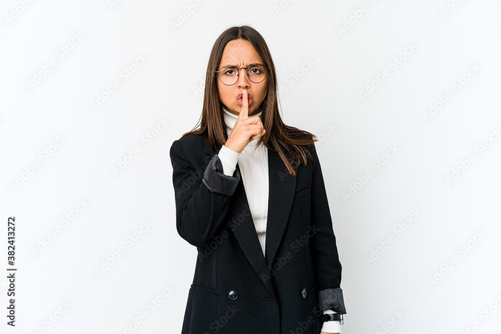 Young mixed race business woman isolated on white background keeping a secret or asking for silence. Young mixed race business woman isolated on white background keeping a secret or asking for silence.