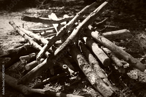 Campfire wood pile next to campsite in black and white.