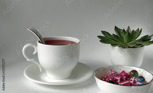 Fruit tea in a white cup with sweet candies