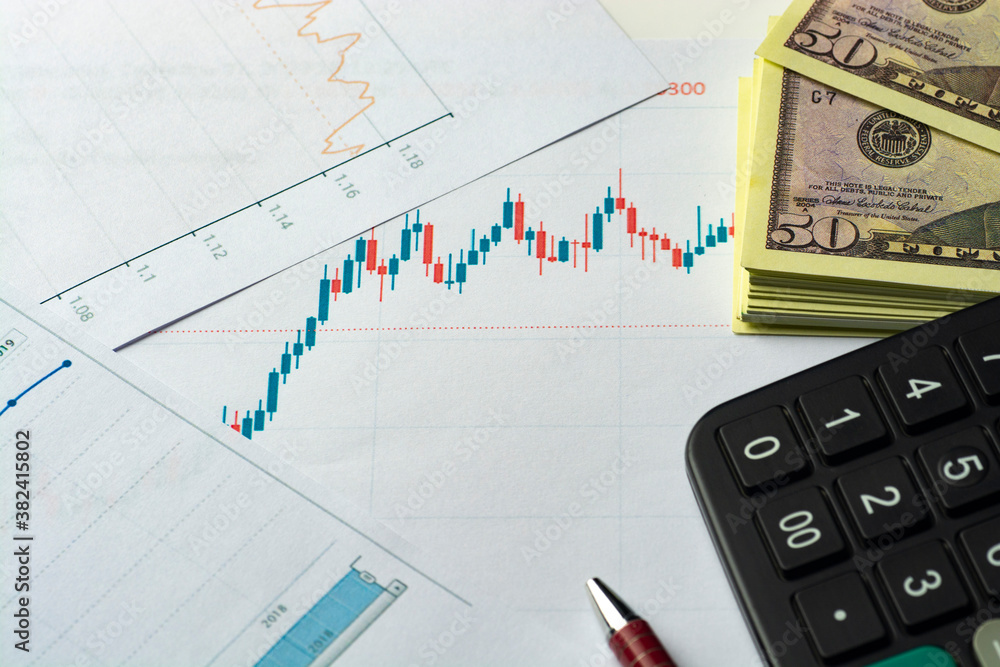 Financial statements. Business Graph. Pen and calculator with dollars bills on a financial chart or stock market data. Financial statements. Business Graph. Pen and calculator with dollars bills on a financial chart or stock market data.