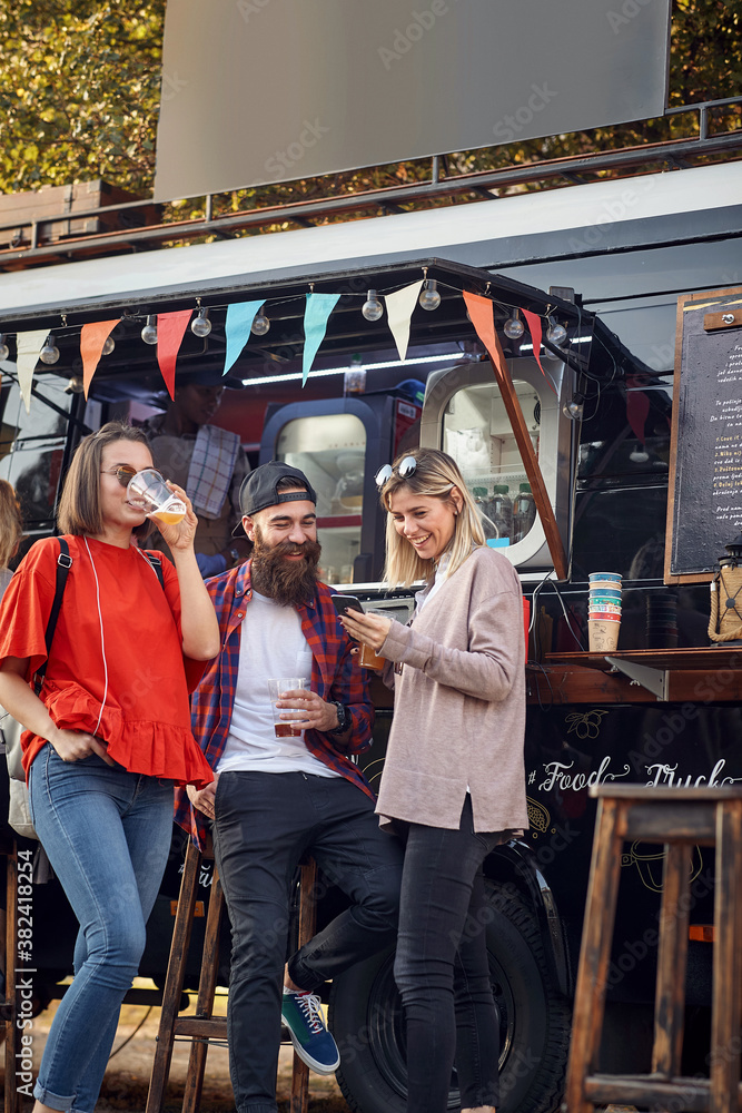 Group of friends hanging out in front of food truck; Urban lifestyle concept