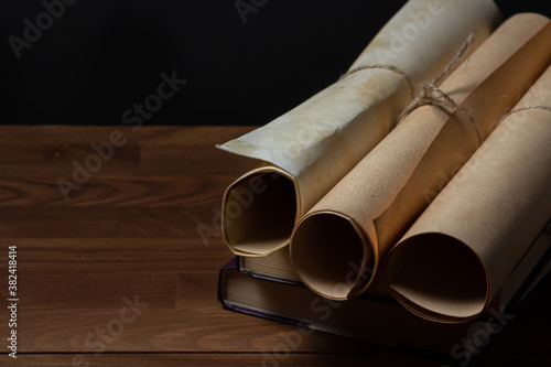 Old scrolls and books on a black background. Education concept.